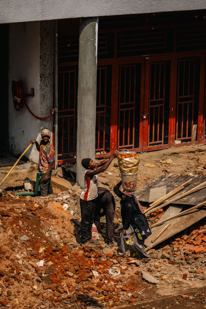 about-03 A group of construction workers engaged in manual labor on a city building site.
